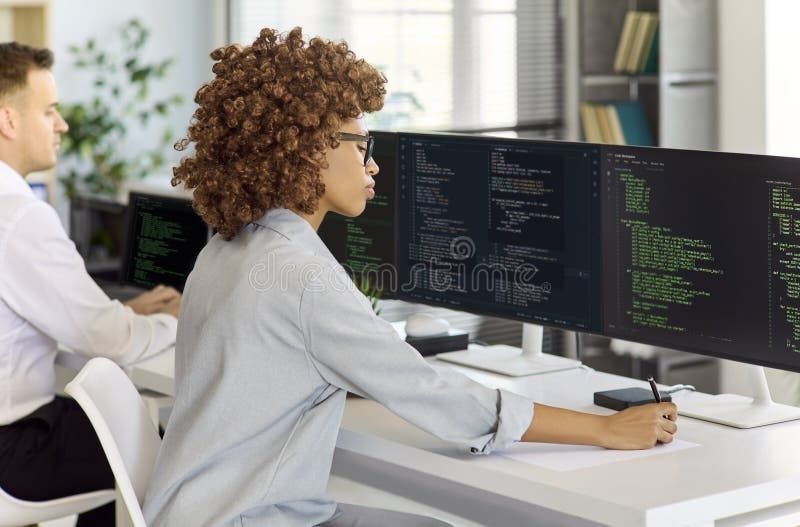 Zwei Entwickler arbeiten an Monitoren mit sichtbarem Quellcode